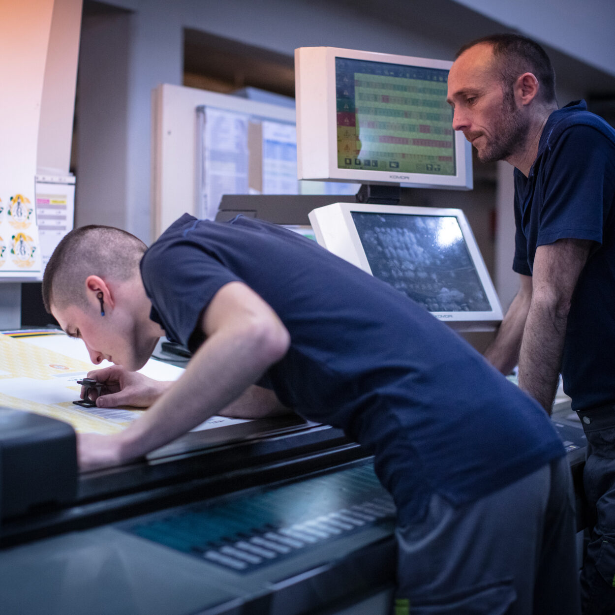 Deux hommes travaillant sur une presse d'impression